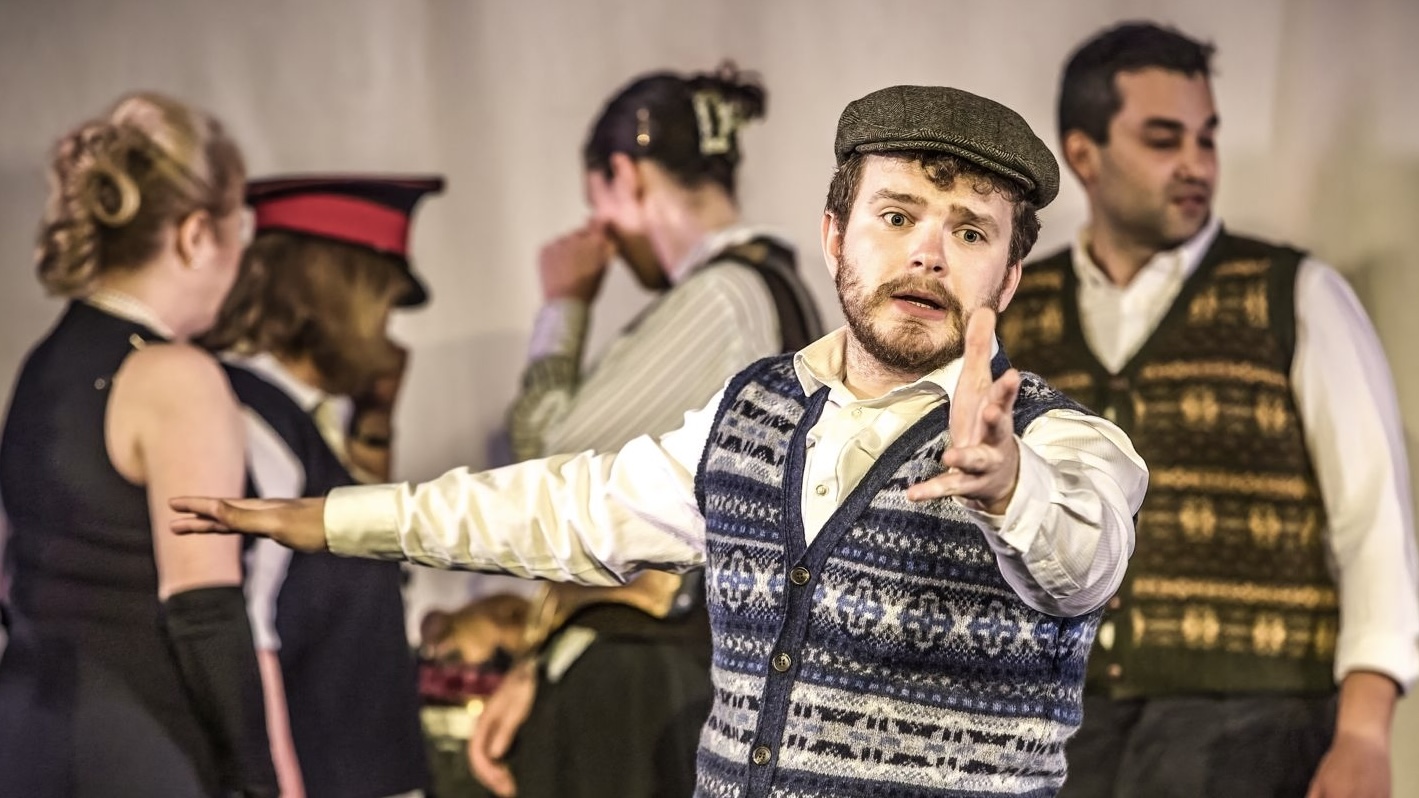 a photo of Chris Murphy with one arm outstretched and a furrowed brow as he sings in St Paul's Opera's produciton of Die Fledermaus